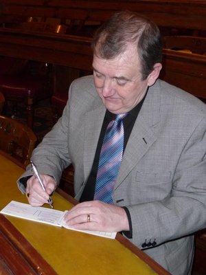Cllr Alan Lewis writing a cheque for the Mayor's Benevolent Fund